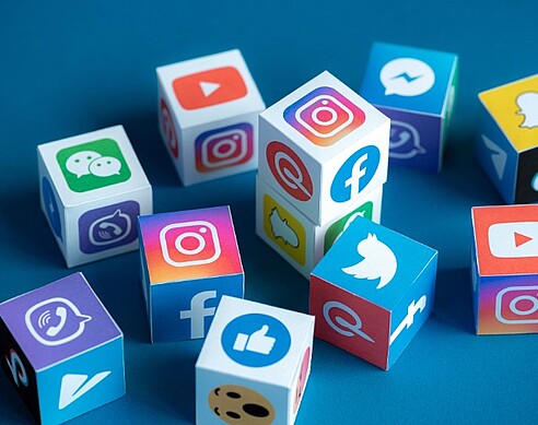 Social Media als Wuerfel-Icons auf blauem Hintergrund