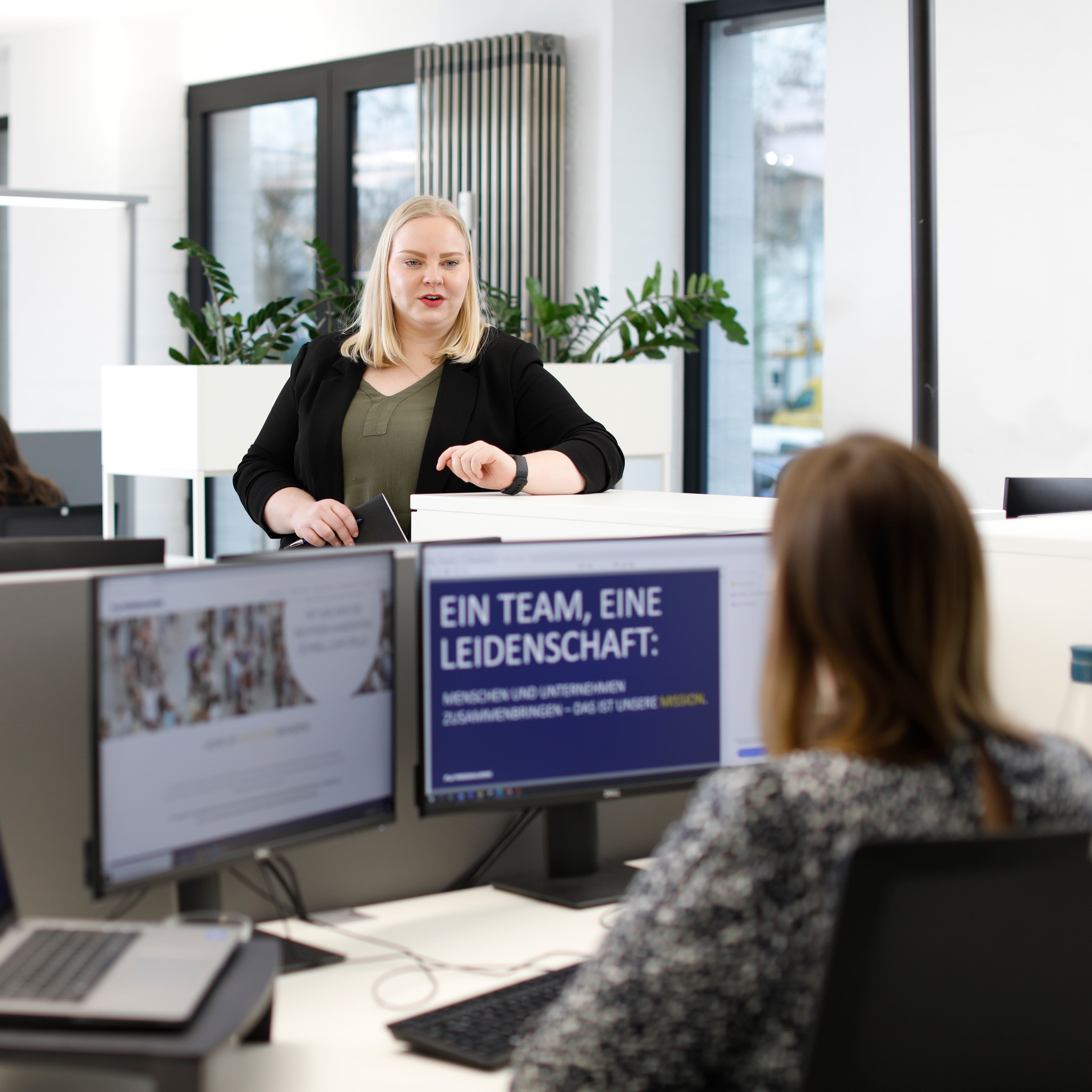  Personalwerk-Team im Büro bespricht Stellenbörse und Karriereseite am Bildschirm