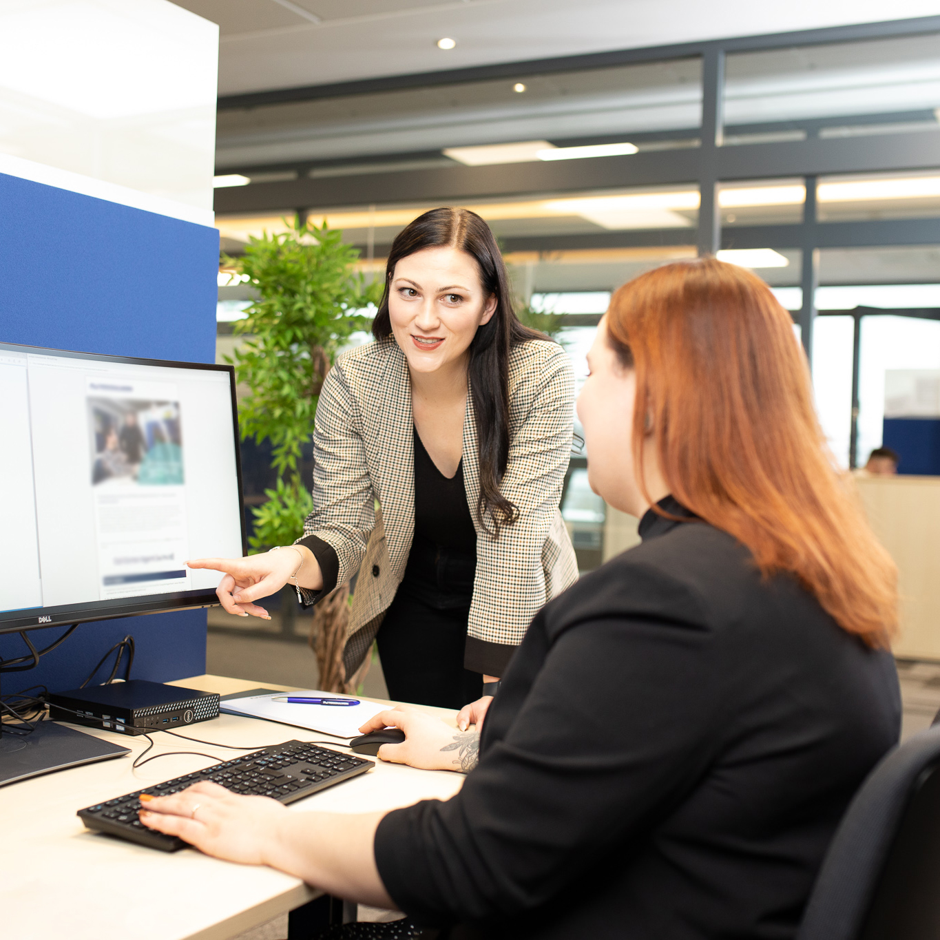 Beraterin zeigt Kollegin am Bildschirm, wie Stellen im Corporate Jobboard erscheinen